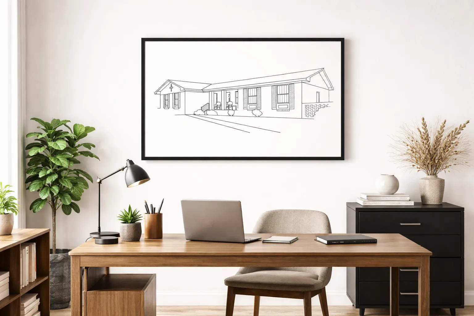 A framed line-art home portrait hanging in a quiet study